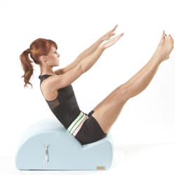 The Pilates Firm Las Vegas - Juliet, the owner, demonstrating a teaser on the spine corrector.