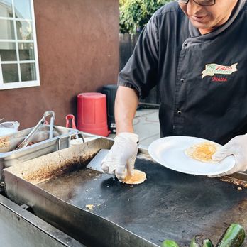 The Taco Guy Catering - Benito adding that cheese to make our tacos even more tasty than it already is! - Caterers Near Me - Pasadena, California