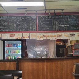 Menu - Chalkboard menu at Sub Brothers in Chicago lists burgers, sandwiches, and fried foods, with prices and sizes.