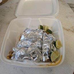 4 tacos wrapped up and lime wedges