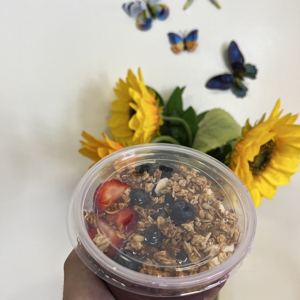 Smakk'D Refreshers & Teas - a hand holding a cup of tea and a vase of sunflowers - Coffee & Tea Near Me - Lakewood, California Smakk'D Refreshers & Teas - a hand holding a cup of tea and a vase of sunflowers - Coffee & Tea Near Me - Lakewood, California