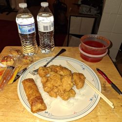 Taste of China - Sweet and sour chicken over rice with egg roll and sweet and sour sauce The water bottles are mine