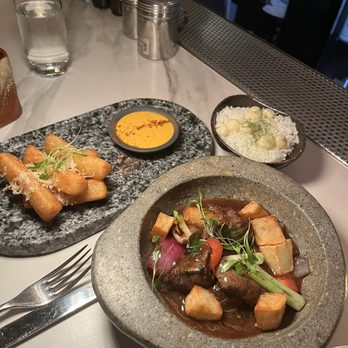 Artesano Peruvian Cuisine - Truffle yucca fries (left) and Lomo Saltado (right) - Peruvian Near Me - New York, New York Artesano Peruvian Cuisine - Truffle yucca fries (left) and Lomo Saltado (right) - Peruvian Near Me - New York, New York