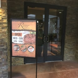 The River Steakhouse - Hours and specials posted outside entrance