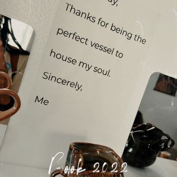 Creative Grounds DC - The art on the walls - A handwritten note on a white wall expresses gratitude to the body, describing it as a vessel for the soul. The note is positioned among pottery pieces and a mirror, with a timestamp indicating it was taken in 2022. The setting appears to be an indoor space with decorative pottery and reflective surfaces. - Art Classes Near Me - Washington, DC, District of Columbia