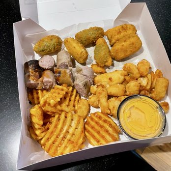 Blue Badger Bar & Grill - Wisconsin Sampler with Jalapeño Poppers, Cheese Curds, beer cheese, waffle fries, and a sliced brat (not the doll) - American Near Me - Sturtevant, Wisconsin