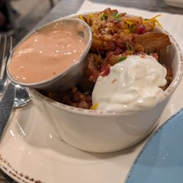 Breakfast potatoes with some delicious sauce and sour cream Breakfast potatoes with some delicious sauce and sour cream