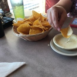 a person dipping tortilla into a bowl a person dipping tortilla into a bowl