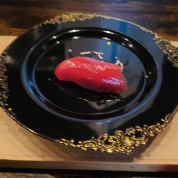 Mottsu - a black plate with a red pepper on it - Japanese Near Me - Brooklyn, New York