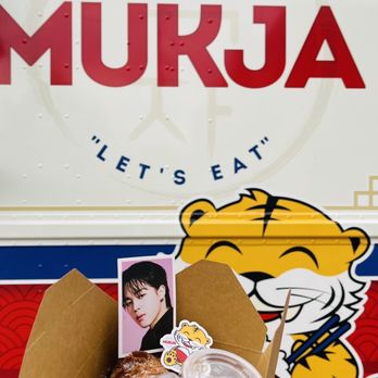 Mukja Food Truck - a person holding a box of food - Food Trucks Near Me - Denver, Colorado