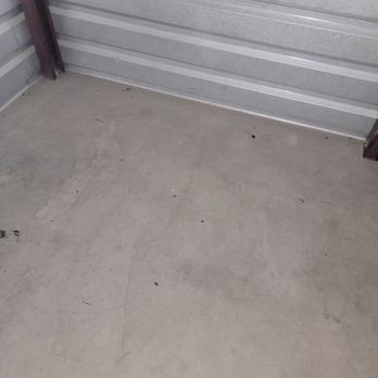 Extra Space Storage - More. - Concrete floor with dirt, small debris, and scuff marks, adjacent to a metal garage door with horizontal panels. - Self Storage Near Me - Phoenix, Arizona