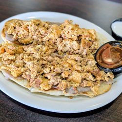 Chorizo with eggs over refried beans on grilled buttered bread.