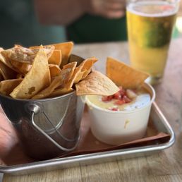 Chips and Smoky Queso and beer in background Chips and Smoky Queso and beer in background