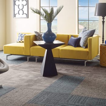 Carpet Express - a living room with a yellow couch and a blue vase - Carpeting Near Me - Clarksville, Tennessee Carpet Express - a living room with a yellow couch and a blue vase - Carpeting Near Me - Clarksville, Tennessee