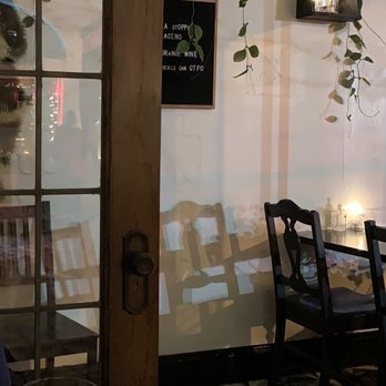 Strange Town - a woman sitting at a table with a glass of wine - Vegan Near Me - Milwaukee, Wisconsin Strange Town - a woman sitting at a table with a glass of wine - Vegan Near Me - Milwaukee, Wisconsin