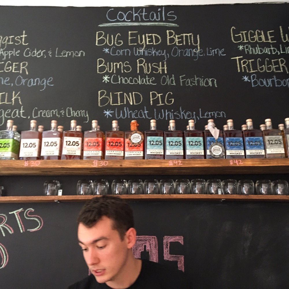 Four Finger Distillery - Menu board and spirits (Nolan making an appearance) - Cocktail Bars Near Me - Indianapolis, Indiana Four Finger Distillery - Menu board and spirits (Nolan making an appearance) - Cocktail Bars Near Me - Indianapolis, Indiana
