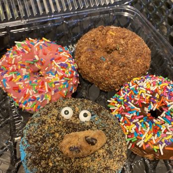 DK's Donuts of Orange - Starting front left clockwise: Cookie Monster, pink sprinkle, cinnamon crumb, and chocolate sprinkle. Got one free! - Donuts Near Me - Orange, California DK's Donuts of Orange - Starting front left clockwise: Cookie Monster, pink sprinkle, cinnamon crumb, and chocolate sprinkle. Got one free! - Donuts Near Me - Orange, California