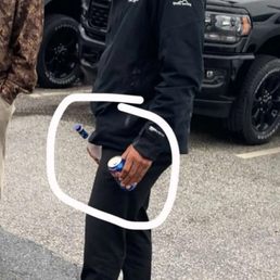 Salesman holding the General managers alcohol that was in a truck they are selling.
