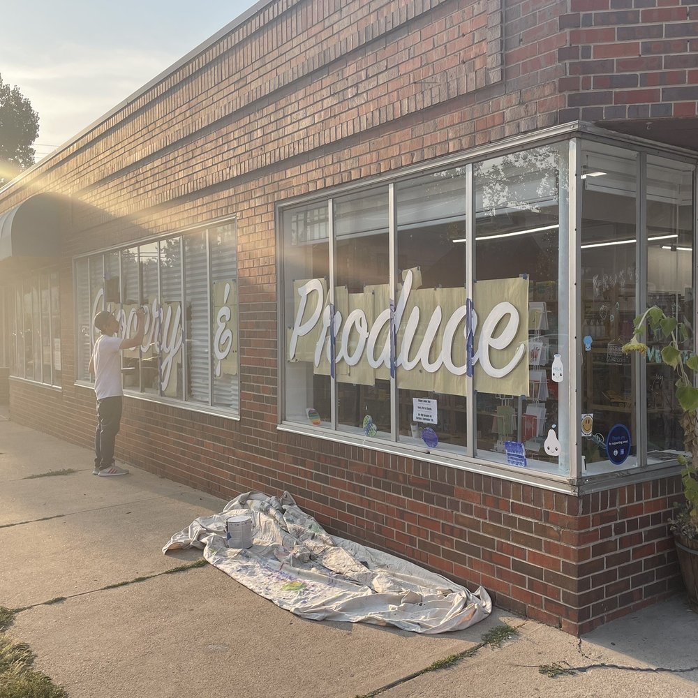Sun Market - a man standing in front of a produce store - Grocery Near Me - Denver, Colorado
