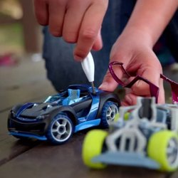 Toys to Treasure - Build, tinker, and race with toy cars from Toys to Treasure! The photo shows hands assembling a blue race car beside a colorf...