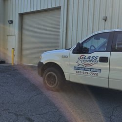 Glass Express - A white Glass Express service truck parked on asphalt outside a tan metal commercial building with a closed garage door.
