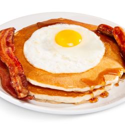 Rosie's Café - Indulge in The Bertha at Rosie's Café--2 large pancakes topped with a sunny-side-up egg, drizzled in syrup, with sides of bacon and sausage!