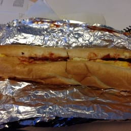 Bacon egg and cheese on a long roll with salt pepper and ketchup