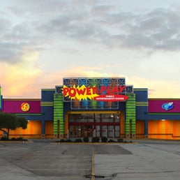 an empty parking lot in front of a brightly lit building