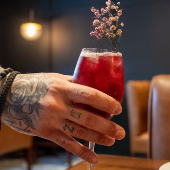 Rebellion Kitchen + Bar - a hand holding a glass of cocktail - Italian Near Me - Danbury, Connecticut Rebellion Kitchen + Bar - a hand holding a glass of cocktail - Italian Near Me - Danbury, Connecticut
