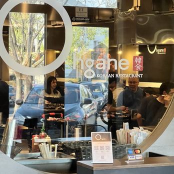 Ohgane - The image captures the interior view of Ohgane Korean restaurant through its glass window, with customers dining and a parking lot outside. - Korean Near Me - Concord, California