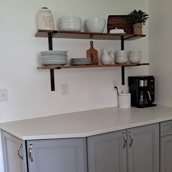 Dole Construction - a kitchen with gray cabinets and white countertops - General Contractors Near Me