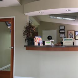 American Dental Office - Clean front desk with neutral restroom in the background.