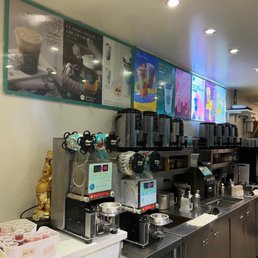 11/16/22 Menu - Interior of a cafe or bubble tea shop with coffee machines, beverage dispensers, and menu boards displaying drinks.