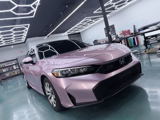 2025 Honda Civic - We wrapped a 2025 Honda Civic that originally came in silver with a full gloss metallic Passion Pink finish. To add some contrast, we did the roof and door handles in gloss black. The pink really stands out and the black accents tie everything together nicely.