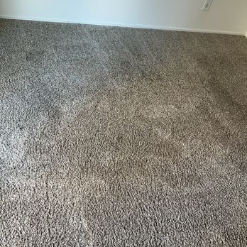 Stanley Steemer - Spots that they refused to reclean  So much for their 'warranty' - Interior room featuring beige textured carpet covering the floor, with white walls and baseboards. Two electrical outlets are visible on the walls, one on the left and one on the right. The room appears empty with no furniture or other objects present, and the lighting is natural or ambient. - Carpet Cleaning Near Me - Oxnard, California
