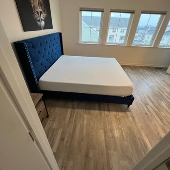 Galo Flooring - a bed with a blue headboard - Flooring Near Me - Cherry Hill, New Jersey