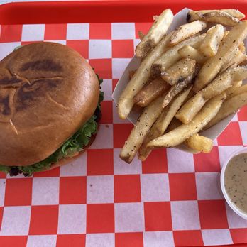 Mr Juicy - Number 2 special. The cup is filled with the sauce that makes the burgers "wet". The ingredients are listed on a sign on the wall. - Burgers Near Me - San Antonio, Texas