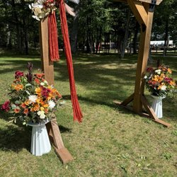 Lutey's Flower Shop - Autumn themed floral arrangement, rented white stands, complimenting bride's own wooden device and artificial decoration/ribbon.