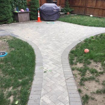Dovale Construction - a brick paver walkway in a backyard - Roofing Near Me