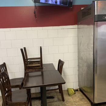 Hyderabad Tandoori - a table and chairs with a television on the wall - Indian Near Me - Queens, New York