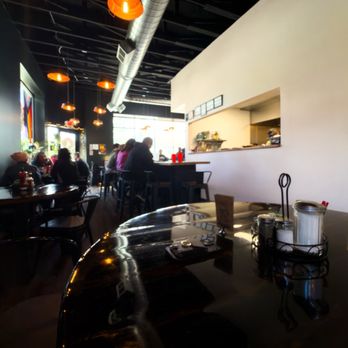 Goat Head - Interior of Goat Head in Salt Lake City, with black ceilings, warm orange pendant lights, an open kitchen, and a small dining room - Breakfast & Brunch Near Me - Salt Lake City, Utah