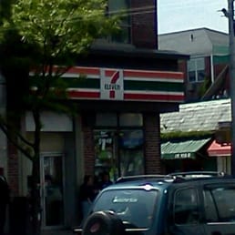 cars parked in front of a 7 - eleven sign