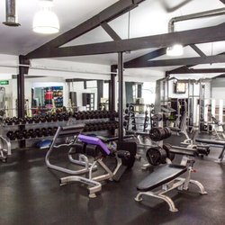 Uptown Fitness - Weight room: dumbbells, barbells, benches.