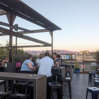 Marble Brewery - The upstairs deck at sunset on a Sunday with mountains behind - Breweries Near Me - Albuquerque, New Mexico