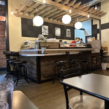 Somkit - A view of the sushi bar, where master sushi craftspeople prepare excellent sushi. - Thai Near Me - Dixon, Illinois