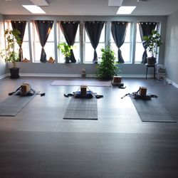 The main yoga studio room at Four Pebbles in East Brunswick, set up with mats and props for a class.