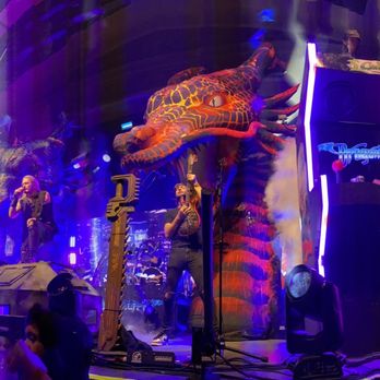 The UC Theatre - a man on a stage with a giant statue in the background - Music Venues Near Me - Berkeley, California