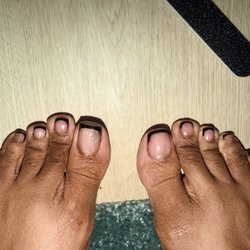 Chillax Nail Lounge - Uneven french tips, left big toe is showing old acrylic through the polish.