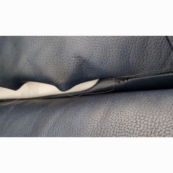 Ashley Store - The entire seam is coming undone! - A photograph captures a close-up view of black leather upholstery, likely on furniture, with a noticeable tear along the seam. The tear exposes the underlying material and indicates damage to the upholstery. - Mattresses Near Me - Redding, California