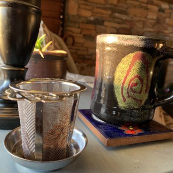 Voila! in Frederick - a cup of tea and a tea strainer - Tea Rooms Near Me - Frederick, Maryland